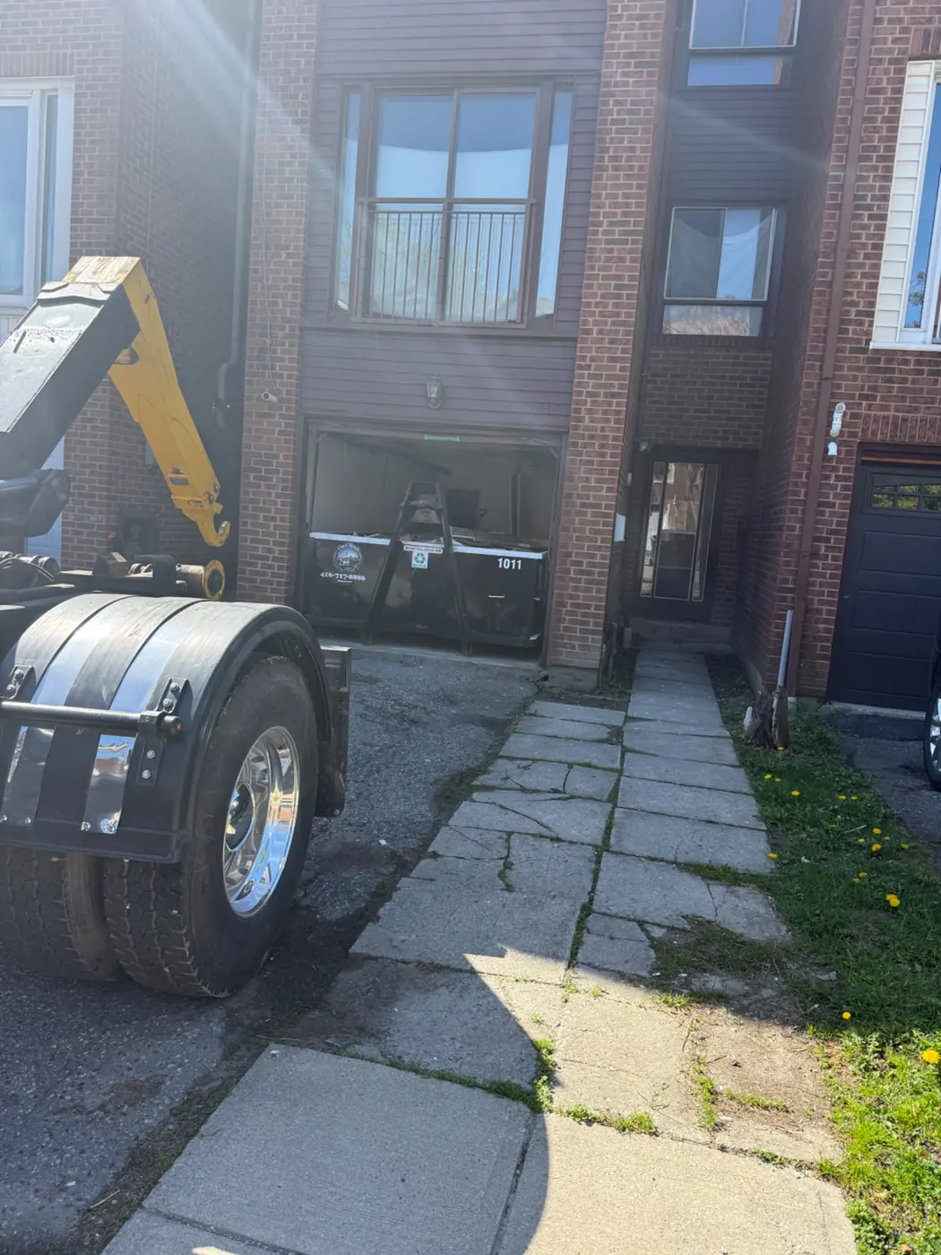 Tiny Bins truck delivering bin to residential driveway
