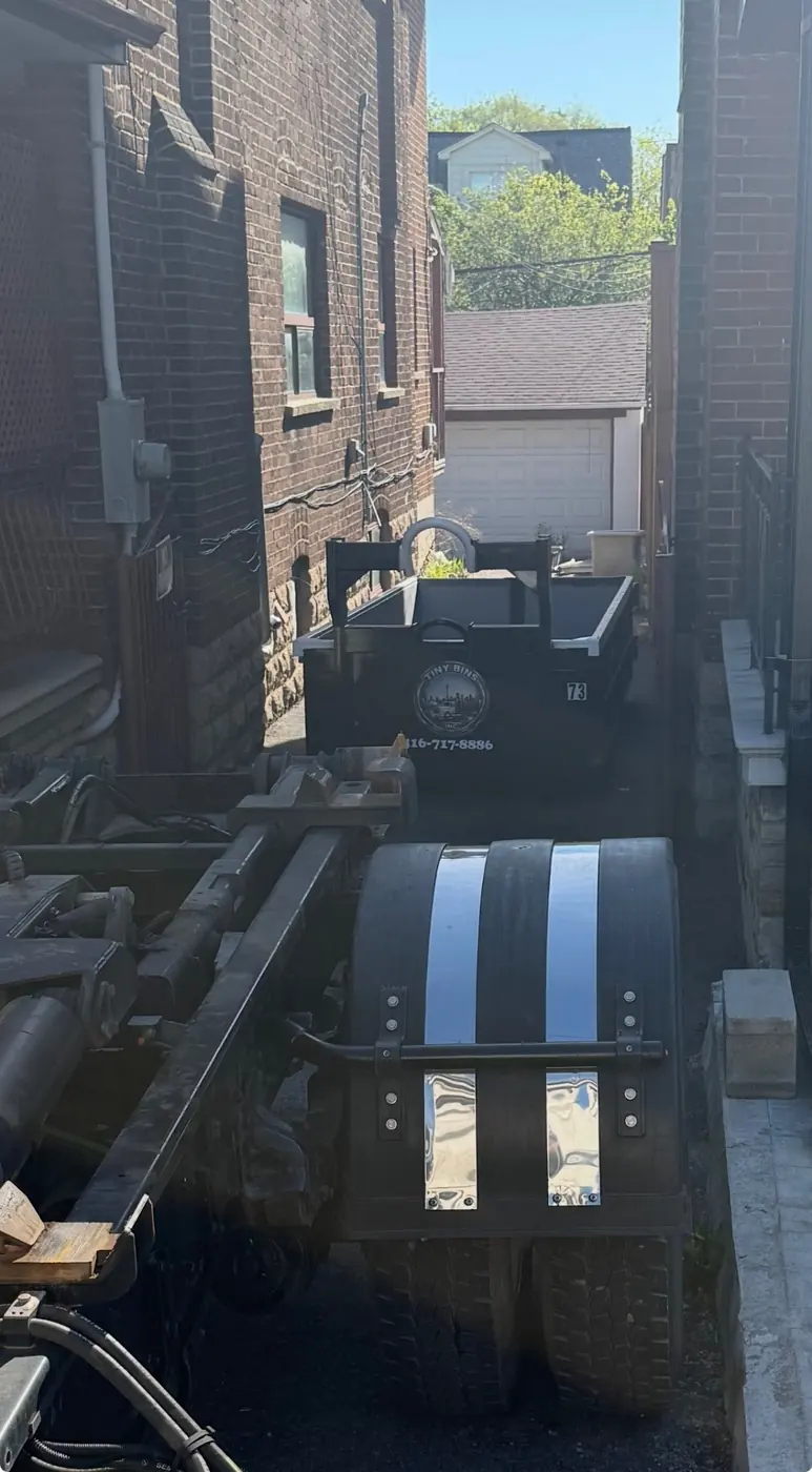 Tiny Bins truck placing bin in narrow residential space